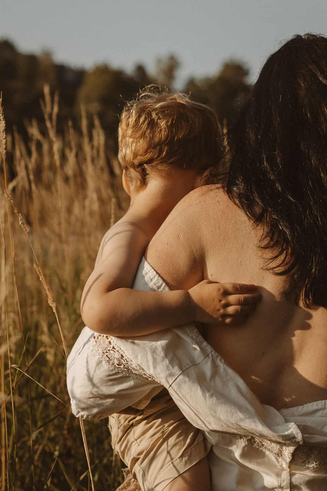Mor og barn i naturen, solnedgang, kjærlighet og nærhet.