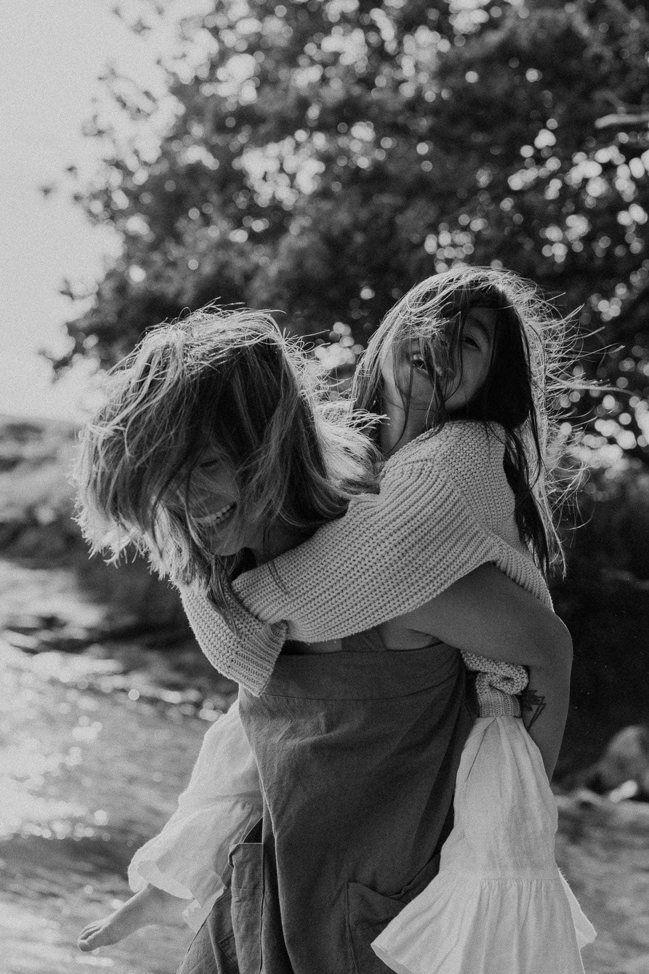 Venninner som leker og har det gøy ved stranden, med naturlig bakgrunn og solskinn.